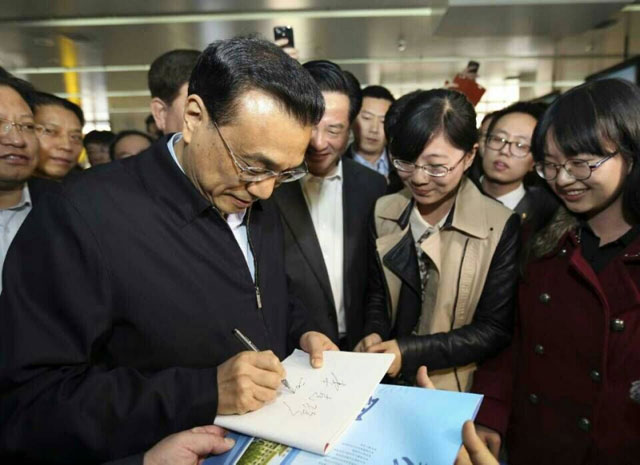 2015年4月10日,李克強在吉林大學(xué)考察,為志愿者簽名。 2015年4月10日,李克強在吉林大學(xué)考察,為志愿者簽名。